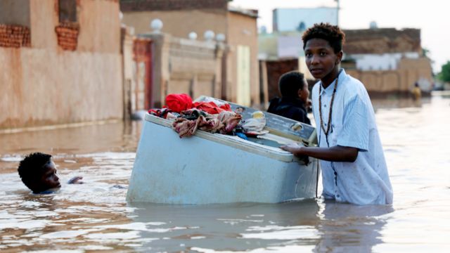 Someone rescuing a washing machine in floods near Khartoum, Sudan - September 2020