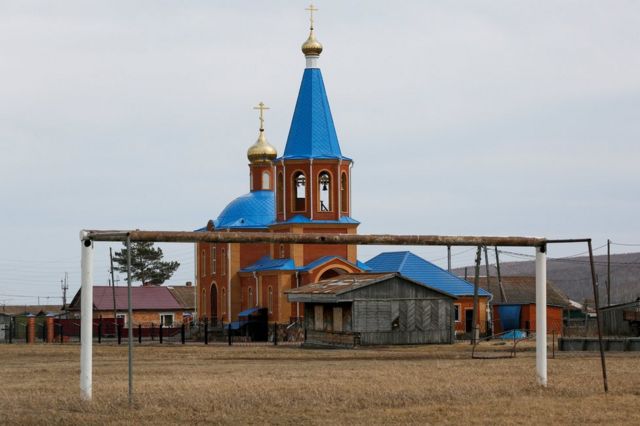 Ворота на фоне церкви в деревне Тюльково в Красноярском крае