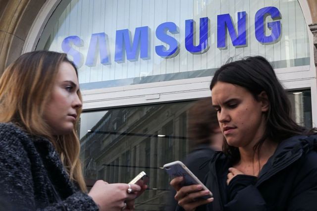 Dos mujeres con celular ante una tienda de Samsung en Londres
