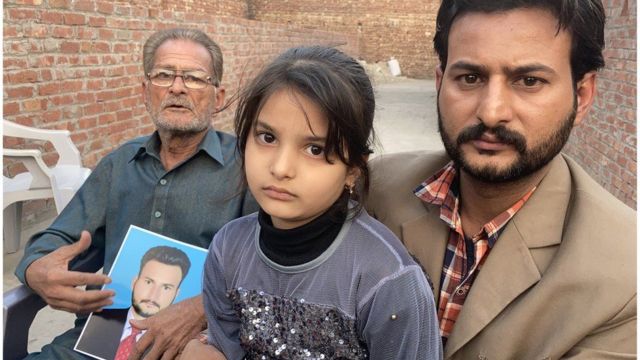 أفراد من عائلة عرفان أحسن يحملون صورة الشرطي المتوفي، الذي كُلف بتوفير الأمن خلال مسيرة مؤيدة لحزب تحريك لبيك باكستان.