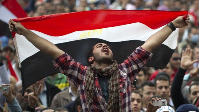 Hombre con una bandera de Egipto en una protesta en 2011