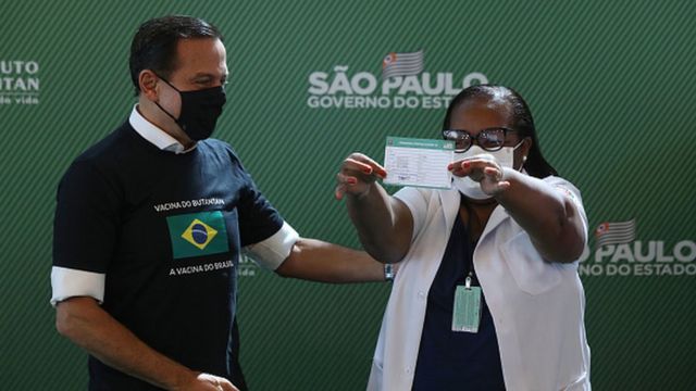 Enfermeira Mônica Calazans mostra comprovante de vacinação ao lado do governador de São Paulo, João Dória