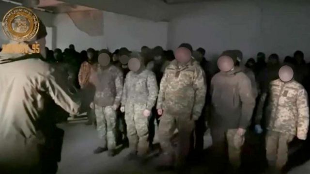 Screenshot of video of prisoners with faces blurred