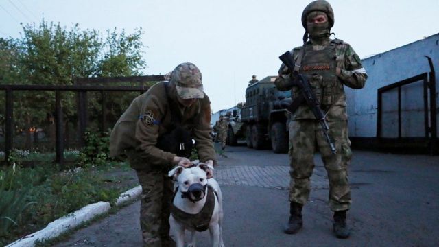 أسير أوكراني يسير مع كلب لتمشيته في سجن أولينيفكا (صورة أرشيفية).