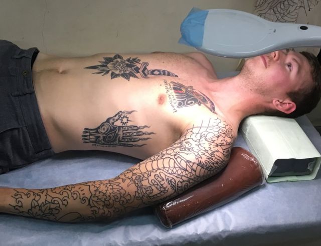 Customer Kyle Seeley lies down in Horimitsu's tattoo studio, waiting to be tattooed
