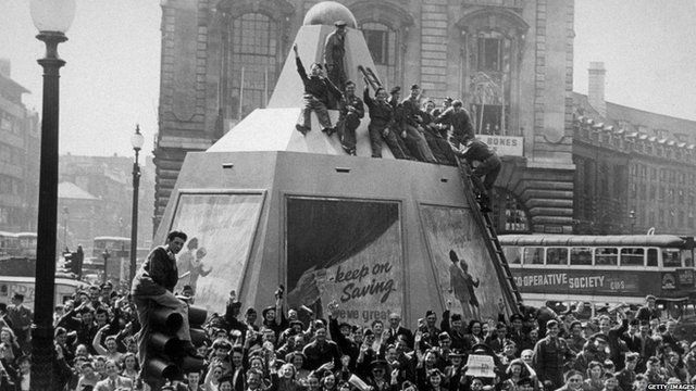 A few minutes after the Japanese surrender was announced, Piccadilly Circus was filled with a jubilant crowd, some of whom climbed on the plinth of the Statue of Eros.