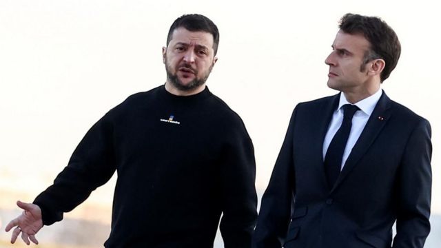 French President Emmanuel Macron (right) walks next to Ukrainian President Volodymyr Zelensky (left) before heading to Brussels, at the Villacoublay military airport, in Velizy-Villacoublay, southwest of Paris