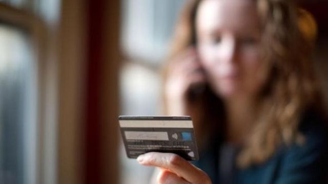امرأة تحمل بطاقة مصرفية