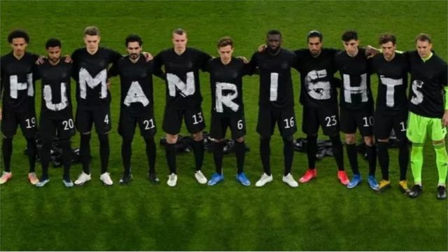 一场世界杯预选赛前，德国队球员身穿黑色衣服组成英文“人权”字样，以示抗议。(photo:BBC)