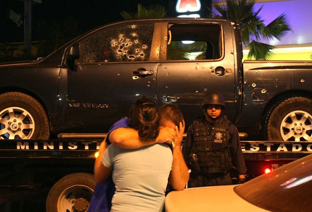A policeman is consoled by his wife after a fatal shootout between narcos and police in Culiacan