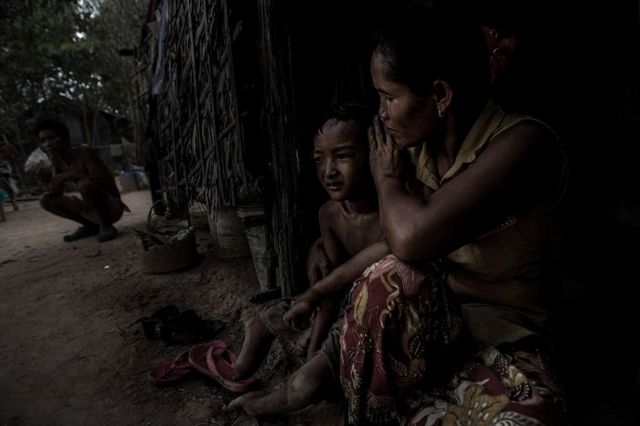 தன் சிறுவயதில் ஏஜென்ட் ஆரஞ்ச் தாக்குதலை எதிர்கொண்ட கம்போடியத் தாயும், முட்டிக்கு கீழே கால்களும், ஒரு கையும் இல்லாத அவரது குழந்தையும்.