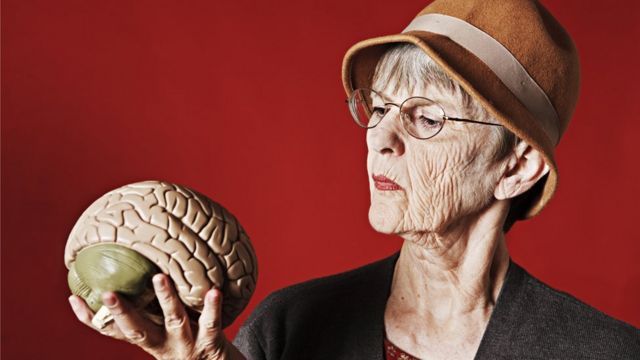 Mujer con un cerebro plástico en la mano