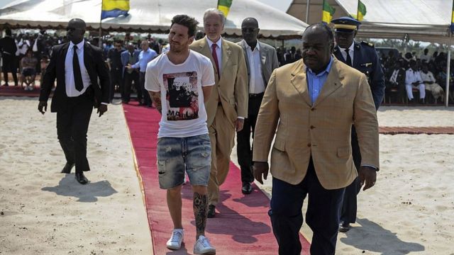 Le joueur de football argentin et quadruple Ballon d'Or de la FIFA Lionel Messi (C) reçoit une visite lors du début de la construction du stade de Port-Gentil par le président du Gabon, Ali Bongo Ondimba (R) dans le quartier de Ntchengue à Port-Gentil le 18 juillet 2015. Le Gabon a ensuite accueilli la Coupe d'Afrique des Nations de football de 2017.
