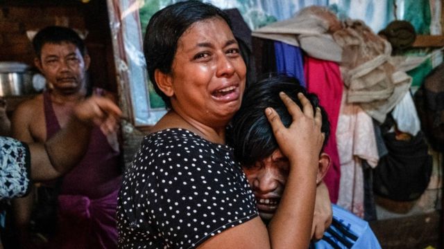 اعضای یک خانواده در برابر مردی که در جریان اعتراضات ضدکودتا در یانگون کشته شد، ۲۷ مارس ۲۰۲۱