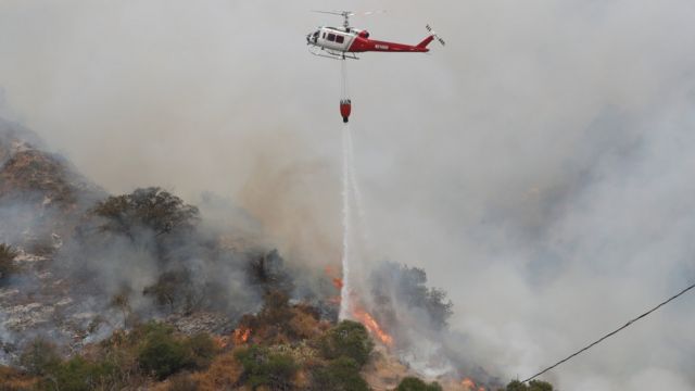 A helicopter drops water to help extinguish the Bobcat fire in Arcadia, California (13 September 2020)