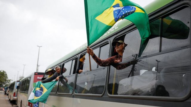 ônibus com apoiadores de Bolsonaro e bandeira do Brasil
