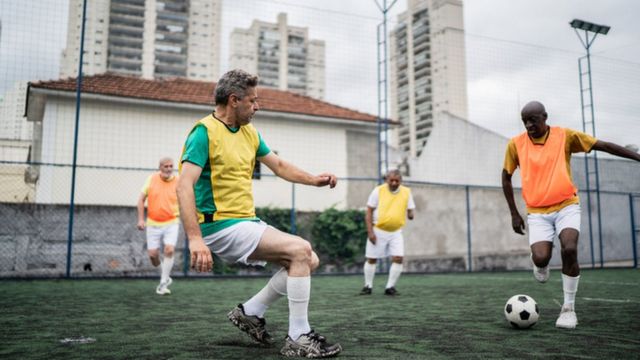 Jogadores De Futebol Sentados Lado a Lado Num Campo De Futebol