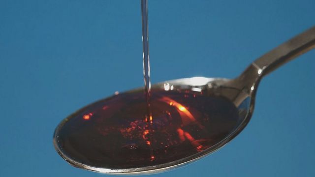 Medicine in the form of syrup poured into a spoon