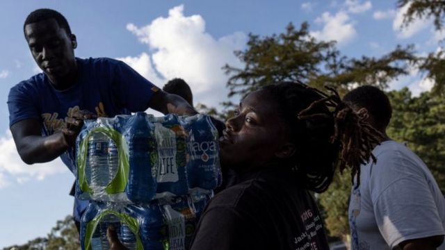 Voluntarios ayudan a repartir botellas de agua en misisipi