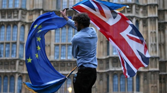 Homem com bandeiras da União Europeia e do Reino Unido
