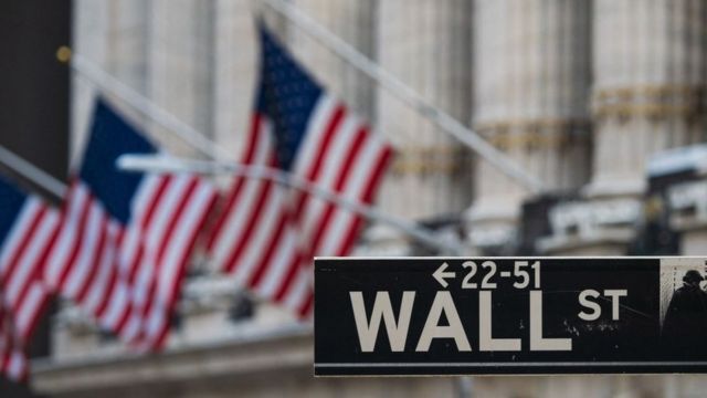 Wall Street sign in front of flags