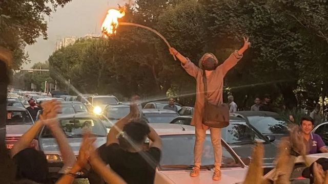 امرأة تشعل النار في حجابها خلال مظاهرة احتجاجية في طهران الاثنين