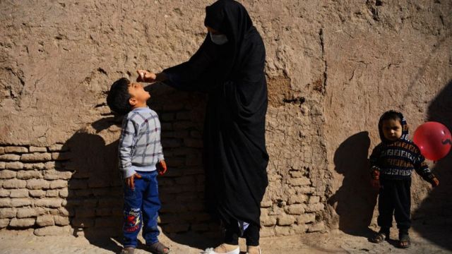 Una mujer vacuna un niño