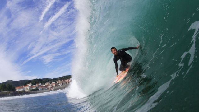 Un hombre hace surf en la playa de la ciudad costera de Mundaka en, el País Vasco, España