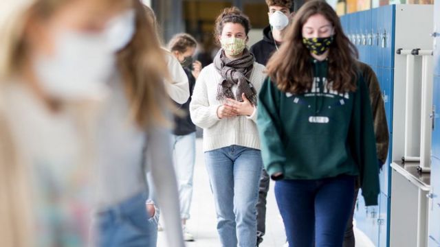 Jóvenes protegidas con máscaras caminan en un centro de estudios alemán.