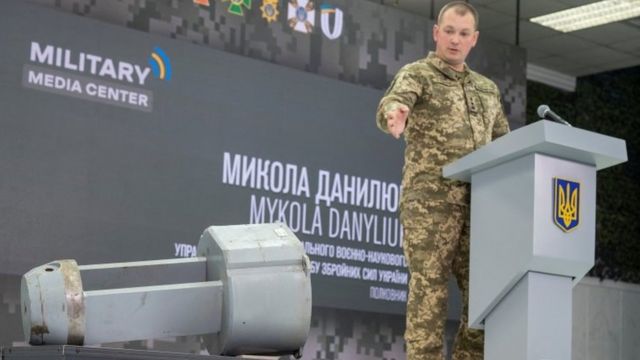 ضابط أوكراني يستعرض شظايا صاروخ