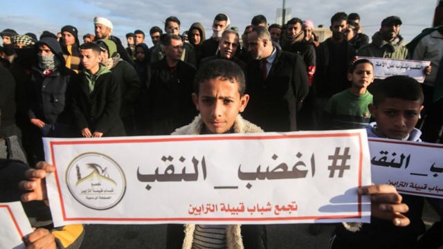 طفل يحمل لافتة تعبر عن رأيه أثناء المظاهرة. فلسطينيون يتظاهرون في رفح جنوب قطاع غزة ضد مصادرة إسرائيل للأراضي الفلسطينية وأعمالها في صحراء النقب جنوب فلسطين.