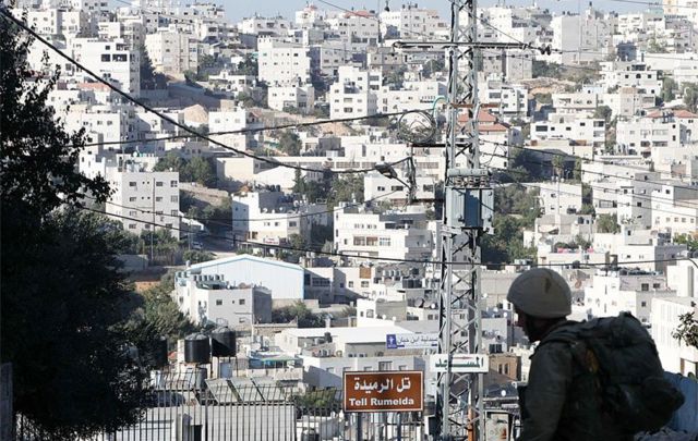 An Israeli soldier stands guard at the entrance to a Jewish settlers zone in Hebron, 2016