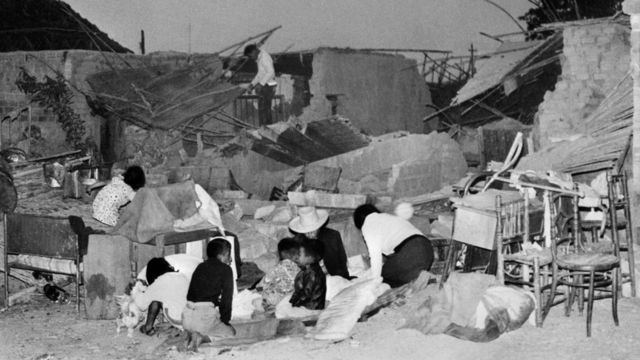 Familias tratando de construir refugios temporales con restos encontrados en las ruinas del terremoto de Perú de 1970