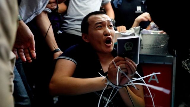 Fu Guohao, reportero del Global Times atado por los manifestantes.