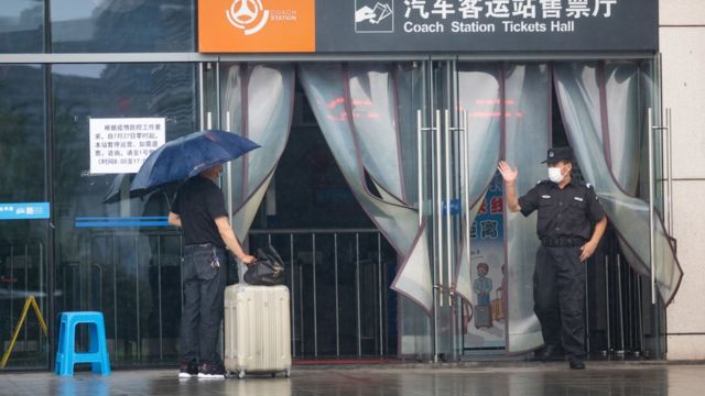 7月27日，南京汽車客運站暫停運營，在售票大廳門口，工作人員與前來乘車的乘客交談。