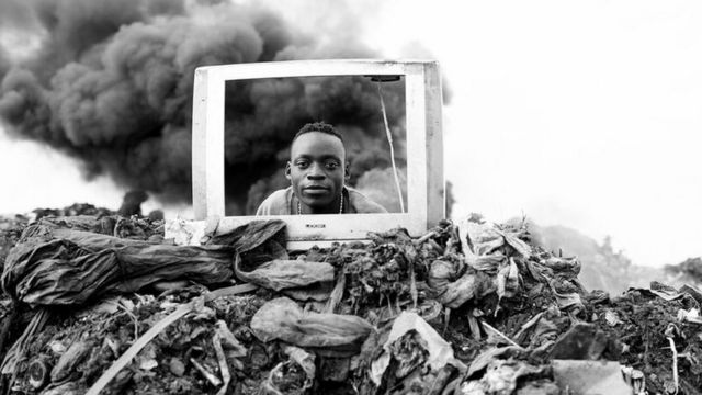 صورة للمصور ماريو ماسيلاو تظهر رجلا ينظر عبر شاشة تليفزيون في مقلب للقمامة في موزمبيق