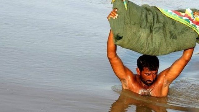Man wading through floodwaters in Larkana, Pakistan