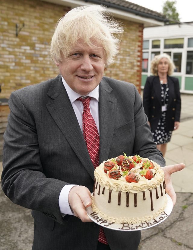 Boris Johnson sosteniendo una tarta de cumpleaños, el 19 de junio de 2020