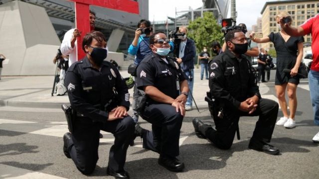 Policiais ajoelhados em um protesto nos EUA