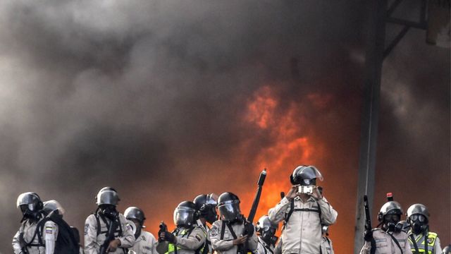 Manifestantes com mascaras e fogo nas ruas durante protestos na Venezuela