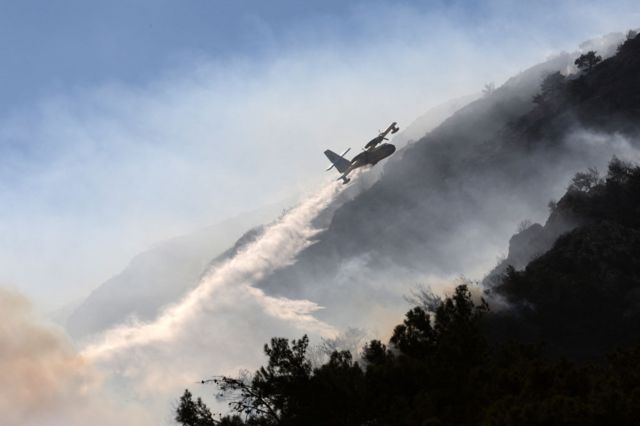 طائرة إطفاء تسقط المياه على حريق غابات شب في منطقة داتشا بمدينة مولا بتركيا