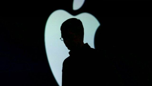 Man standing in front of the Apple logo