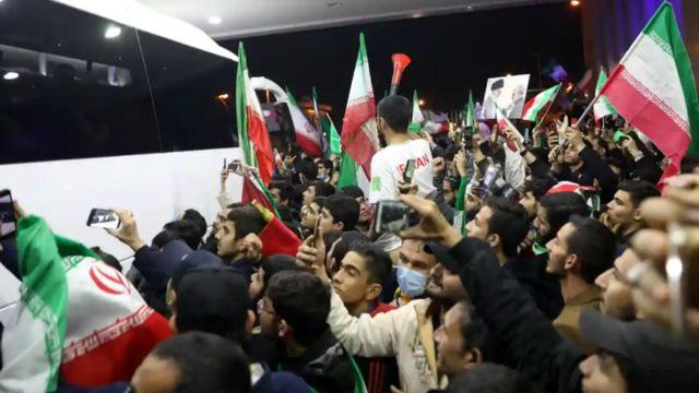 مشجعون يحيطون بالحافلة التي كانت تقل المنتخب الإيراني لكرة القدم أمام مطار الإمام الخميني، بعد كأس العالم لكرة القدم في قطر.