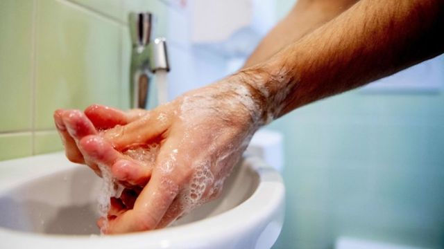 Un hombre lavándose las manos