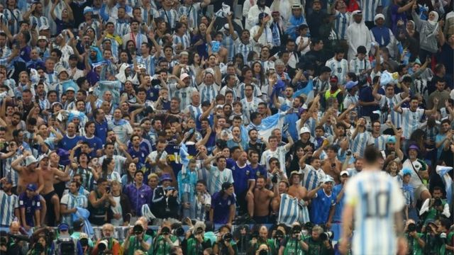 Argentina fans celebrate in front of Messi