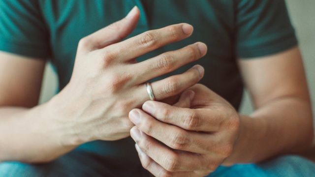 Primer plano de unas manos de hombre con un anillo.
