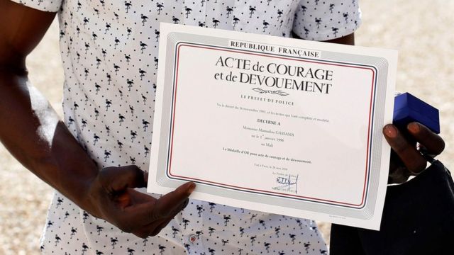Mamoudou Gassama muestra el diploma de valor entregado por el presidente Macron