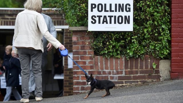 伦敦Coulsdon某投票站外一名女士拖着小狗进门（8/6/2017）