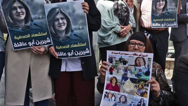 متظاهرون في الضفة الغربية يحملون ملصقات احتجاج على مقتل أبوعاقلة