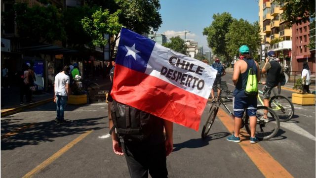 manifestante con bandera chilena que dice chile despertó